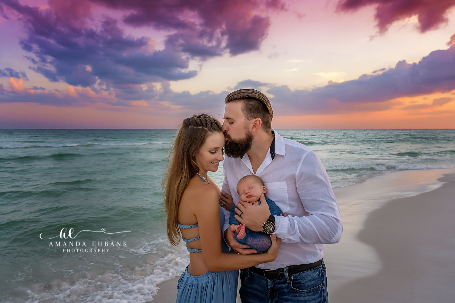 Santa Rosa Beach Maternity Photographer – Sunset Beach Maternity Portrait Expecting couple embracing on the beach at sunset, the man kissing the pregnant woman’s forehead, photographed by a Santa Rosa Beach maternity photographer