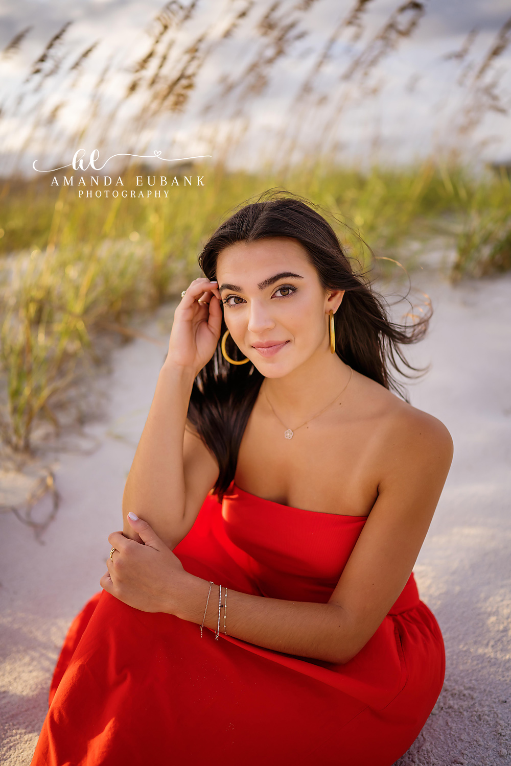 Santa Rosa Beach Senior Photographer – Golden Hour Senior Portrait in the Dunes Close-up senior portrait of a young woman with gold hoop earrings among the beach grasses and dunes at golden hour, photographed by a Santa Rosa Beach senior photographer