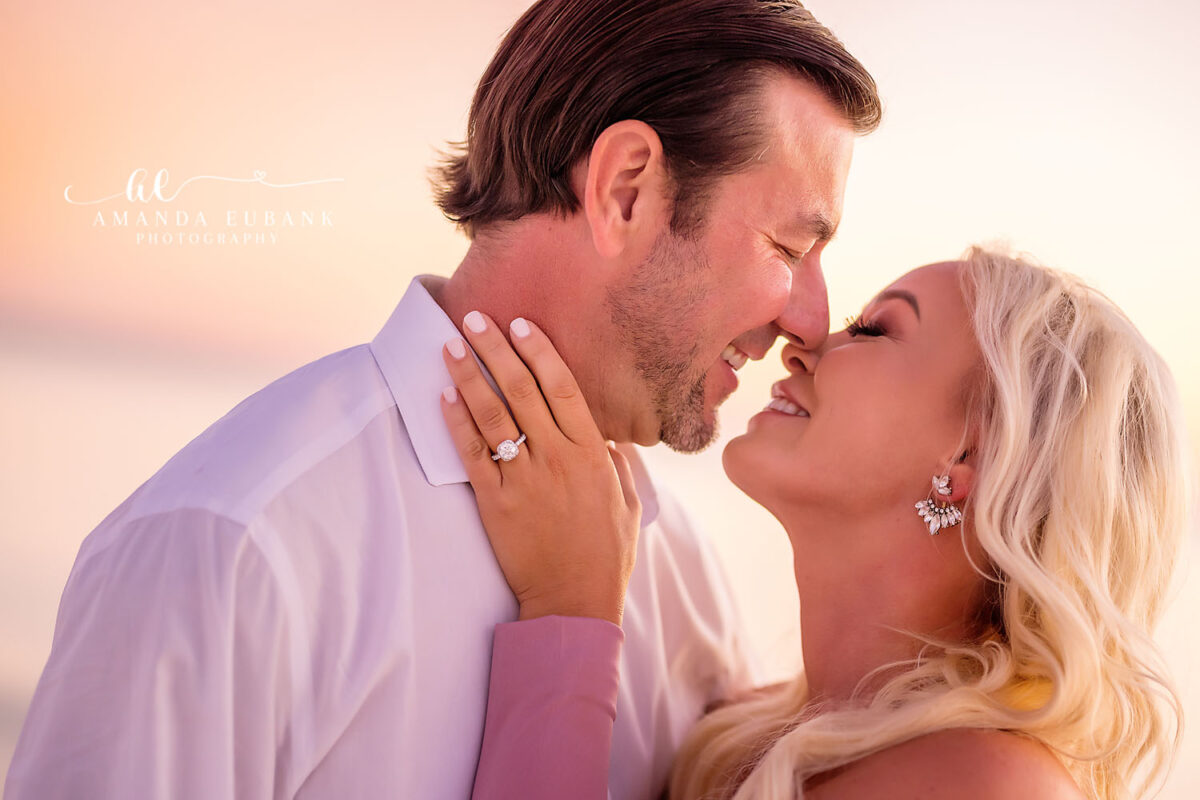 Close-up of a couple leaning in to kiss as the woman’s hand rests on the man’s neck showing off her engagement ring, photographed by a Santa Rosa Beach engagement photographer